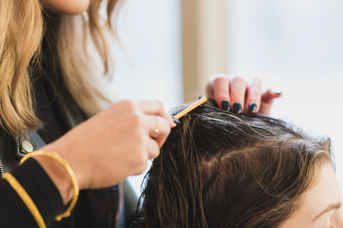 Stylist applying balayage color at Creative Touch Day Spa in Tupelo, MS